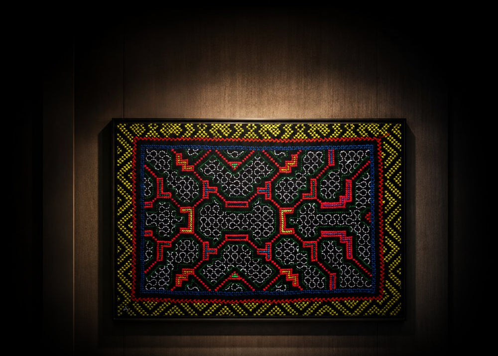 NII SHINAN Kené canvas on a dark wooden wall